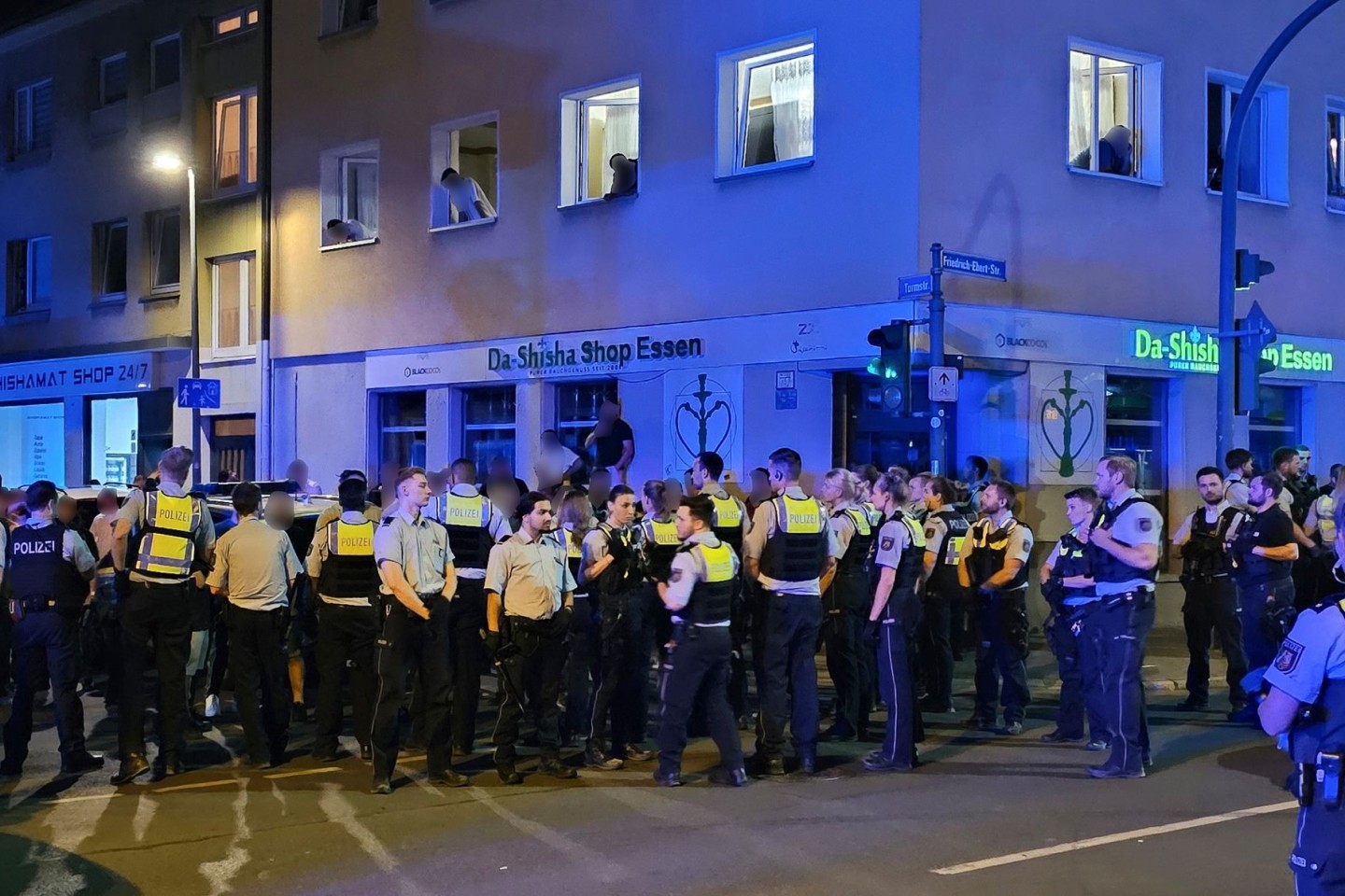 Polizisten bewachen mutmaßliche Teilnehmer einer Massenschlägerei in der Essener Innenstadt.